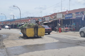 Bak Sampah BLHK Mengacam Maut PM, Kualasimpang - Bak sampah milik Badan Lingkungan Hidup dan Kebersihan (BLHK) Aceh Tamiang diletakKan di tengah badan jalan, tanpa memikirkan kesalamatan para pengguna jalan, baik pejalan kaki maupun pengendara bermotor yang melintasinya. Fenomena yang mengundang maut itu terekam pada, Senin (10/8) sekira Pukul 12.34 WIB, di tempat pembuangan sementara (TPS) sampah.  Bak tersebut terletak di kawasan persimpangan jalan Cut Nyak Dhien/Suparman, persis di depan ruko eks. stasiun Kereta Api Kota Kualasimpang. Foto: Syafruddin Buhfa.