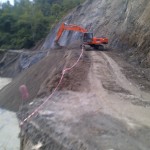 Alat berat terlihat membuang tanah ke dalam sungai saat proses pengerjaan jalan buka tutup di jalan lintas nasional Blangkejeren menuju Takengon.